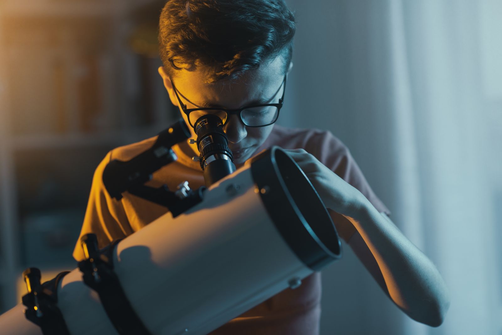 Youth looking through a telescope at home