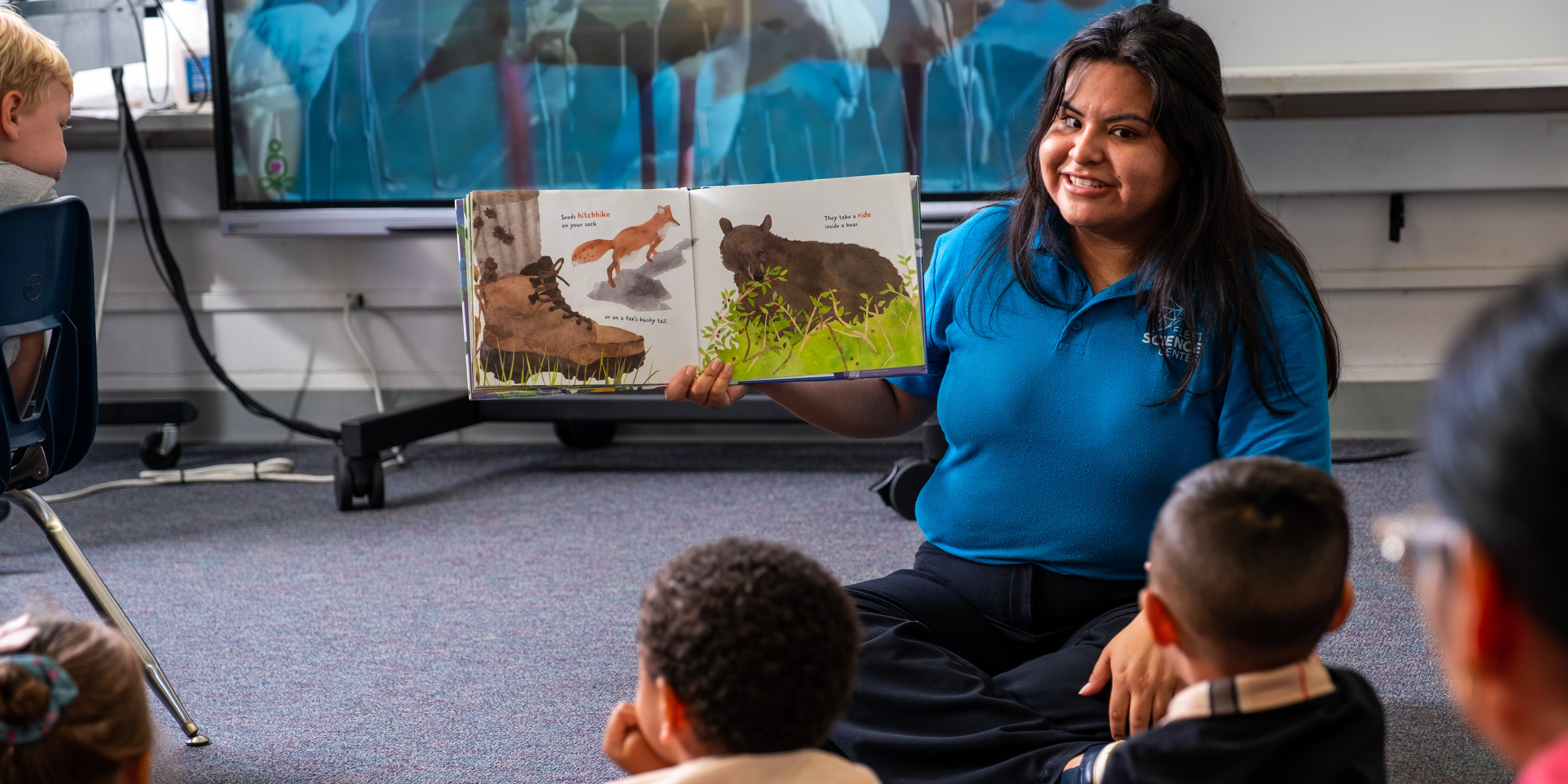 Fleet educator reading to a classroom of young students.