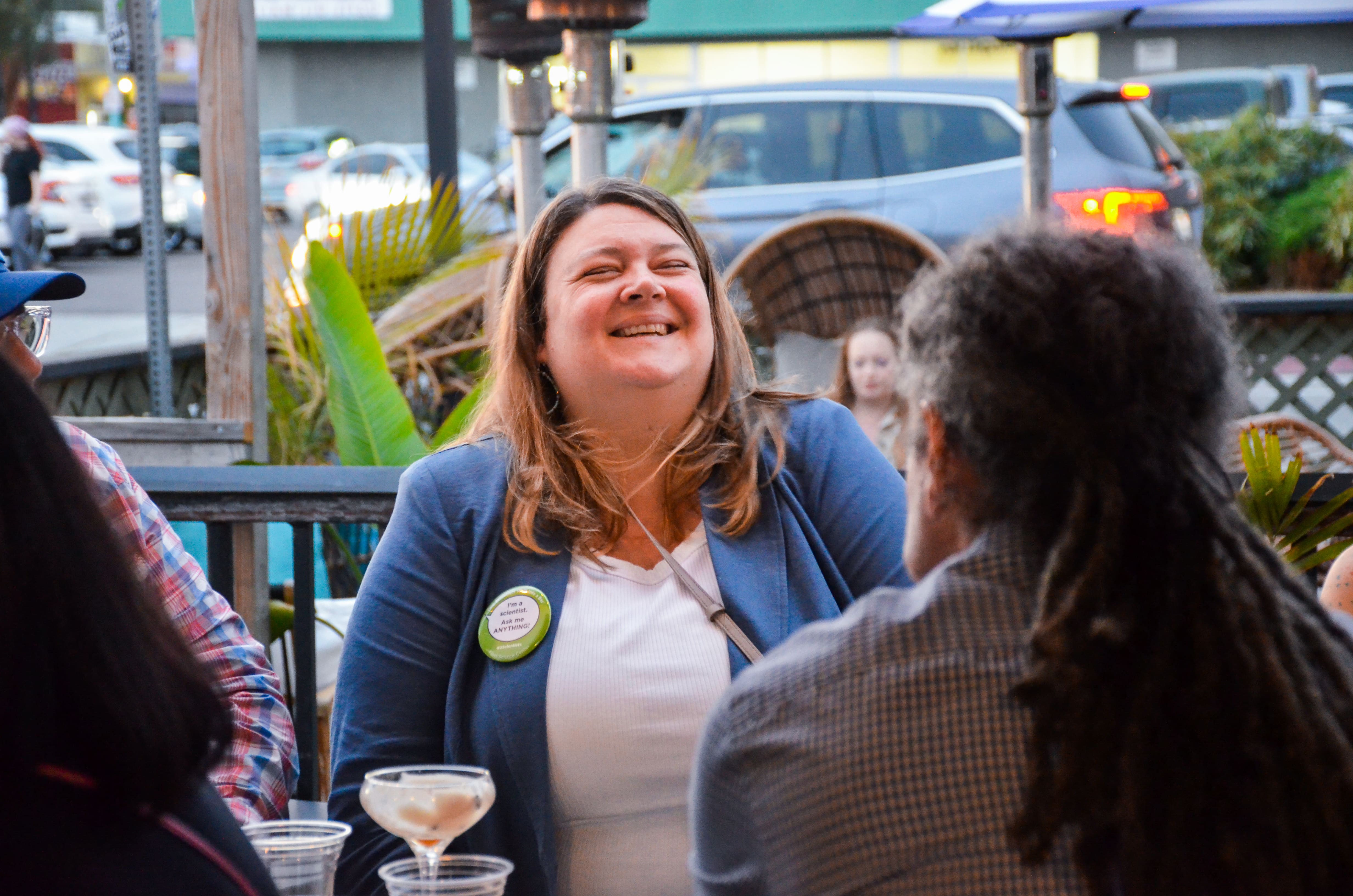 A cheerful woman smiling warmly, exuding happiness and confidence, captured in a candid moment.