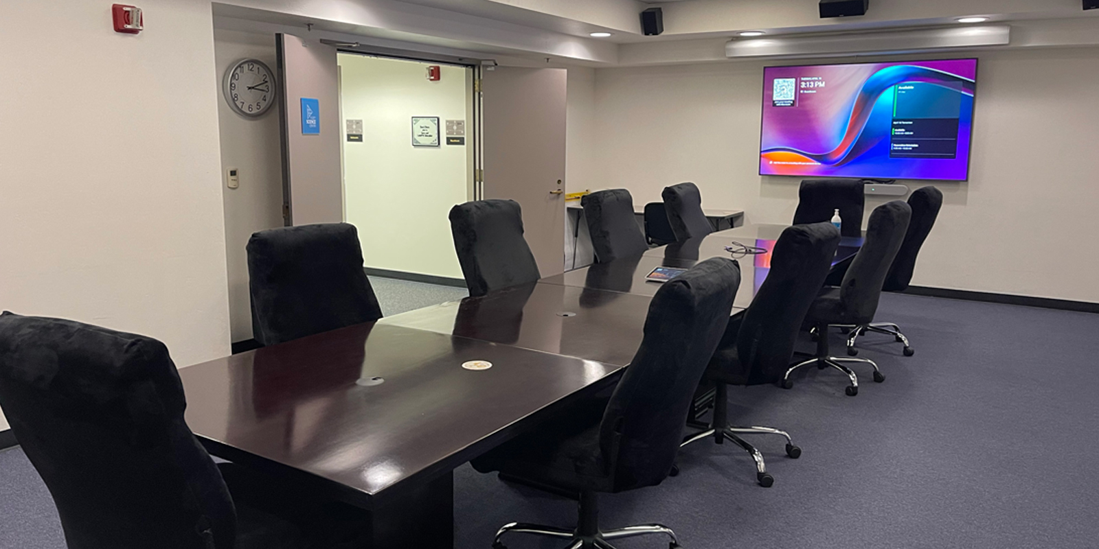 The boardroom A modern conference room equipped with chairs and a large screen, suitable for meetings and presentations.