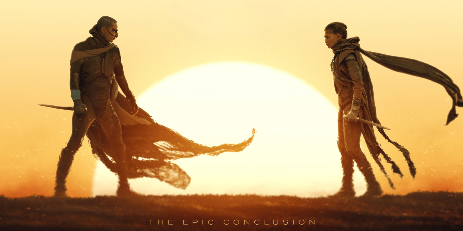 image of man and women standing in desert setup upon a setting sun