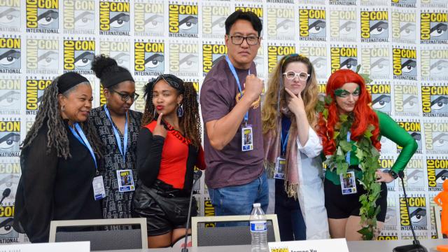 Group of six people stand together with a Comic-Con backdrop