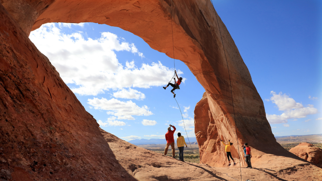 Five hikers scaling a rock formation.