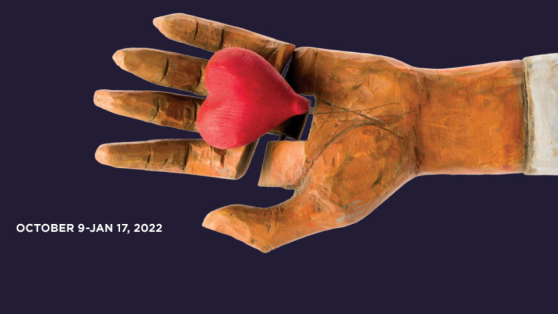 Image of a mechanical hand holding a red heart with text that reads "October 9–Jan 17, 2022.