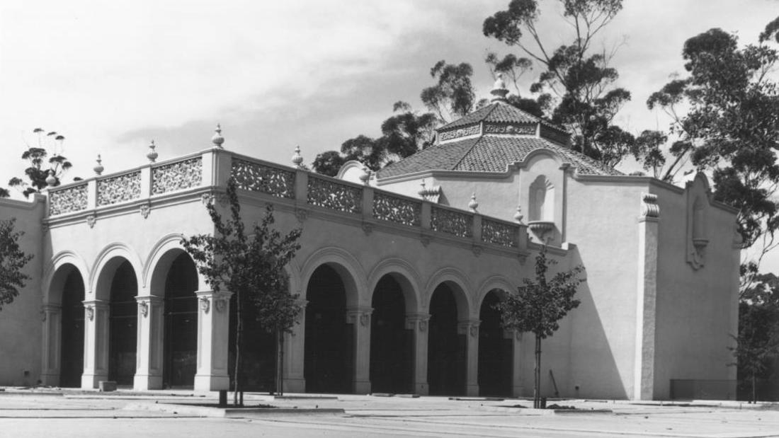 Black and white image of the Fleet Science Center building with columns and a large archway