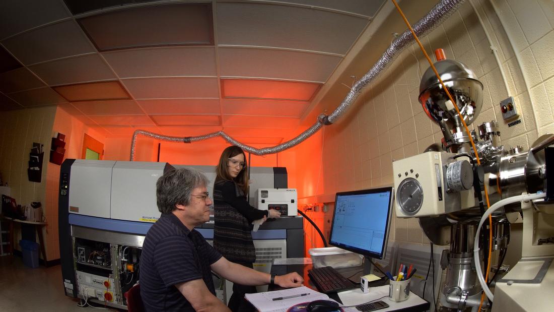 Two researchers look at data inside of a lab.