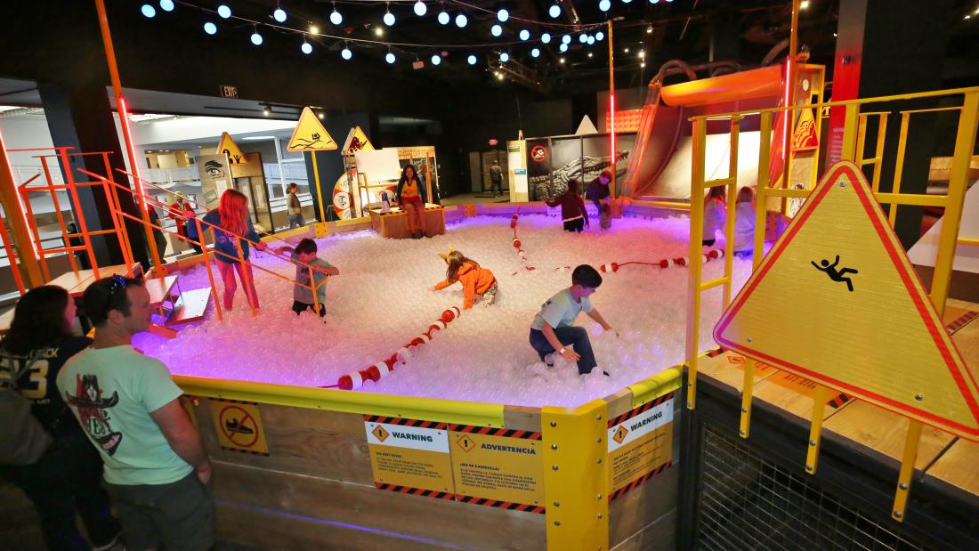 People playing in a large ball pit.