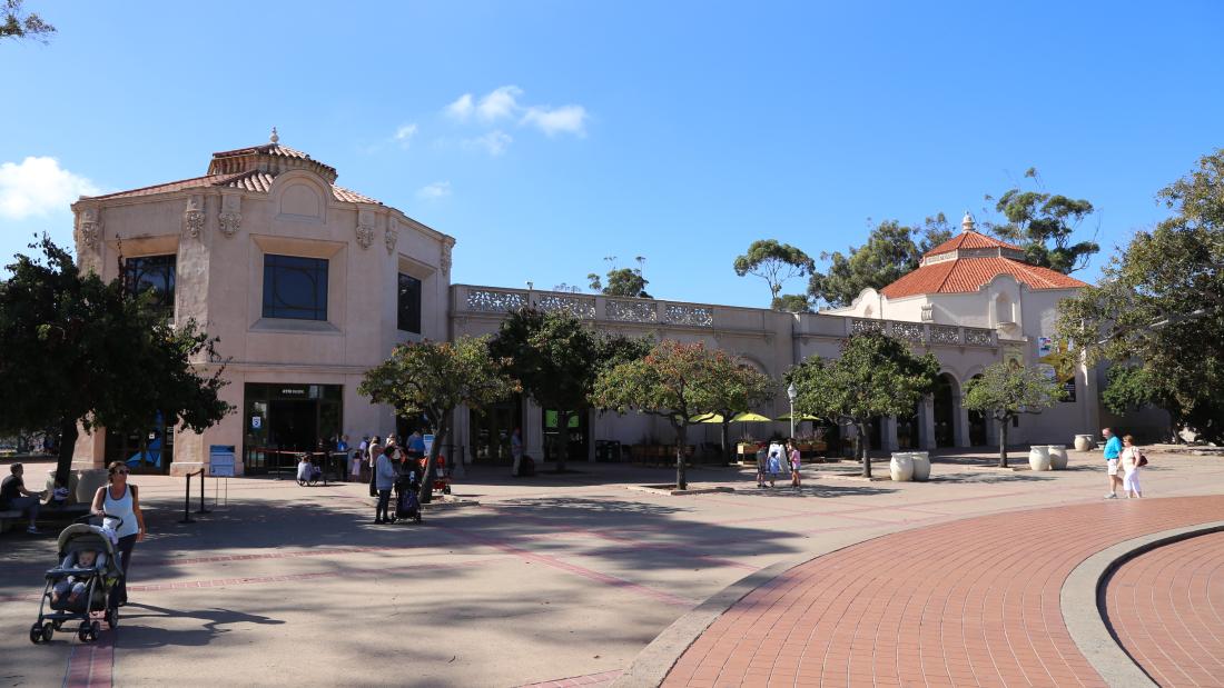 Tan building, the Fleet Science Center, on a sunny day with blue skies and trees