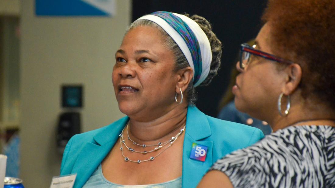Mwenda KudumuBiggs, Ph.D., Vice President of Community Service and Engagement Woman in a teal jacket speaking