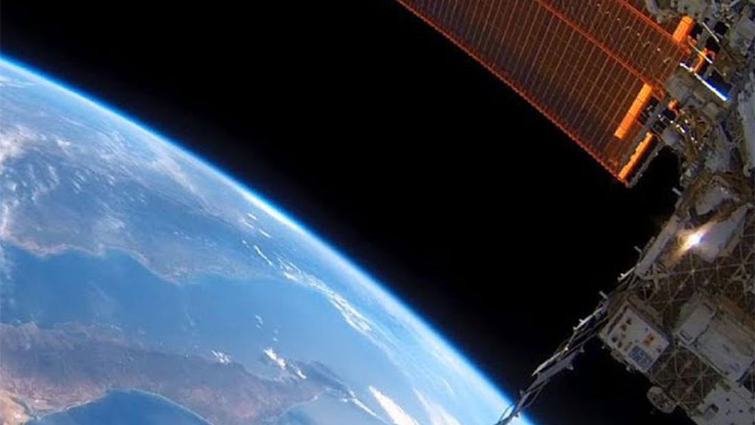 The bottom left is the blue curve of the earth and in the top right is the International Space Station