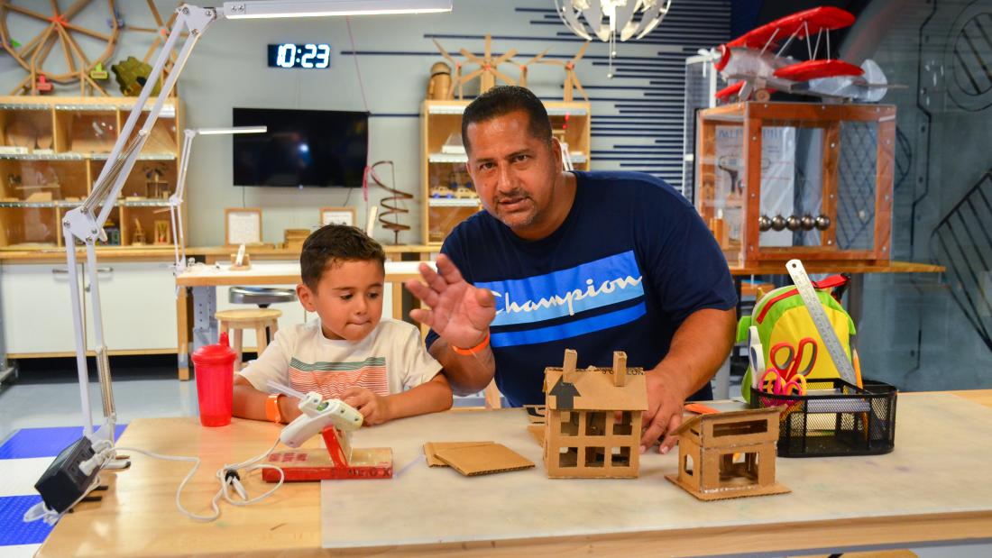 Father and son building cardboard houses in Studio X