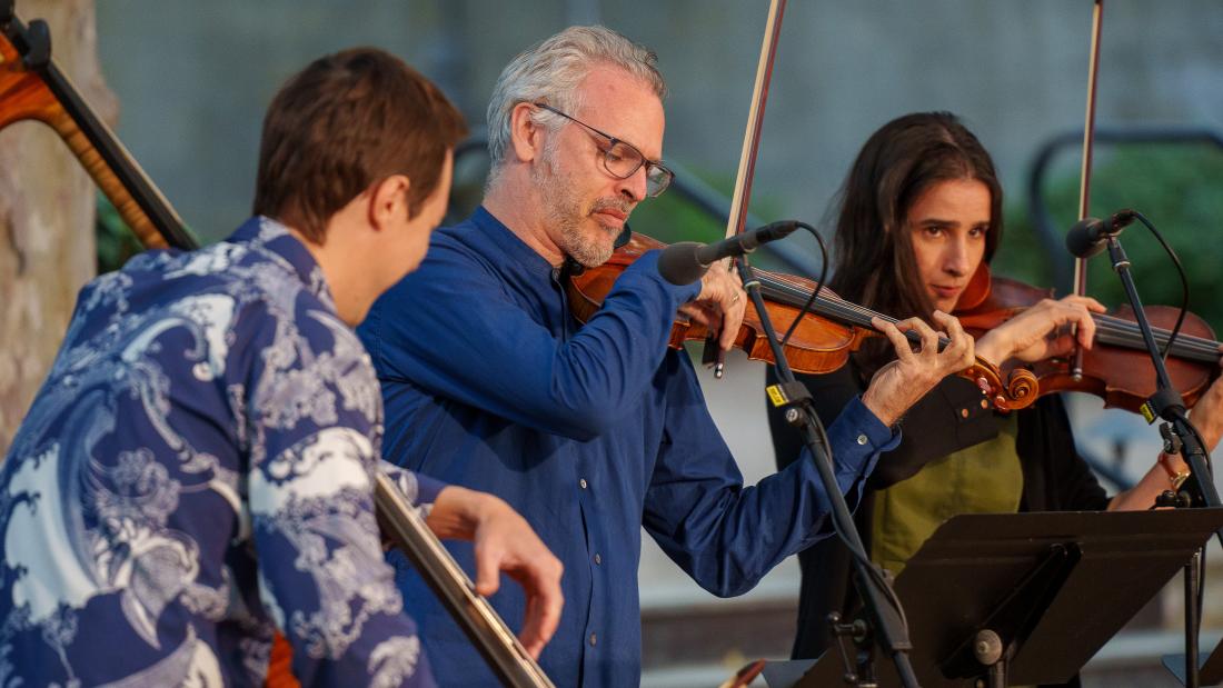 Musicians playing instruments outdoors.