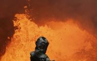 A person from behind standing in front of a spout of lava