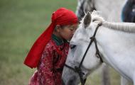 A young child shows affection to a horse.