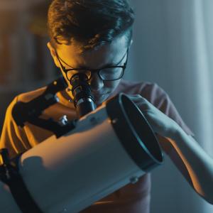 Youth looking through a telescope at home