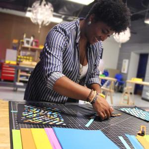Woman tinkering with colored paper on a cutting mat