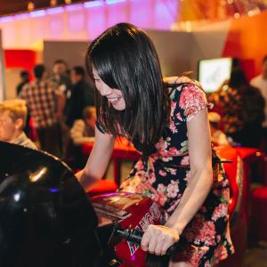 Young woman riding a stationary bike in a floral dress 