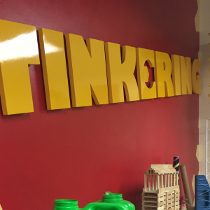 Yellow letters that say "tinkering" on a red background 