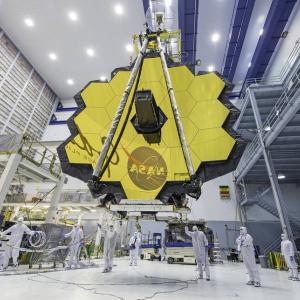 NASA technicians use a crane to lift and move the James Webb Space Telescope, with its 21-foot primary mirror deployed, inside a clean room at NASA’s Goddard Space Flight Center in Greenbelt, Maryland, in April 2017. Credits: NASA/Desiree Stover