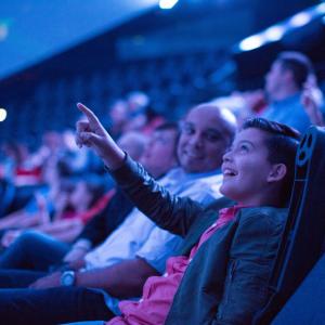 Parent and child look on in awe inside a dome theater