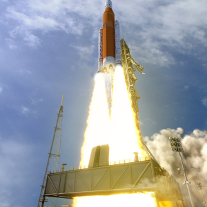 Photo of a rocket launching into space with a large trail of fire and smoke below it.