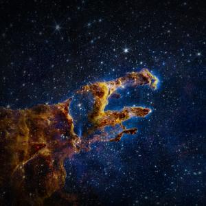 The pillars of creation hang over deep blue black open space