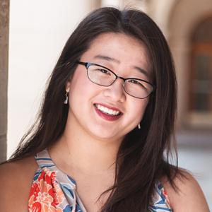 Katelyn Miyasaki. Portrait of a woman of asian descend wearing glasses and short-sleeve blouse and long black hair.