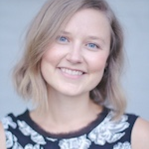Dr. Jessica Cassin. Dr. Jessica Cassin. Blond woman smiling on dark dress with white flower stamped.