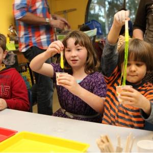 children play with slime inside a classroom at the fleet science center