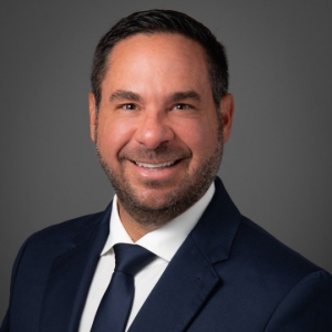 A portrait of a smiling man on dark suit
