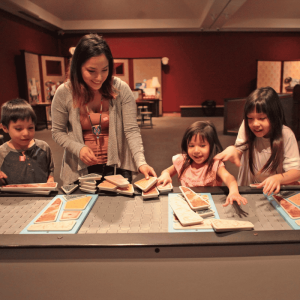 A family solves a puzzle in the Mindbender Mansion exhibit